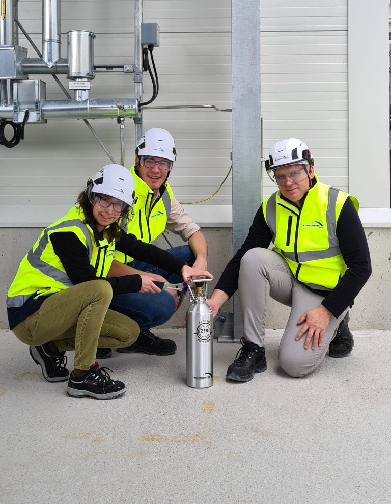 (Von links) Martina Schwarzmüller, Thomas Mairegger und Philipp Stadler von Net Zero Emission Labs, mit frisch abgefülltem Kohlendioxid aus der Rohrdorfer CO2-Rückgewinnungsanlage. Copyright: Rohrdorfer Unternehmensgruppe