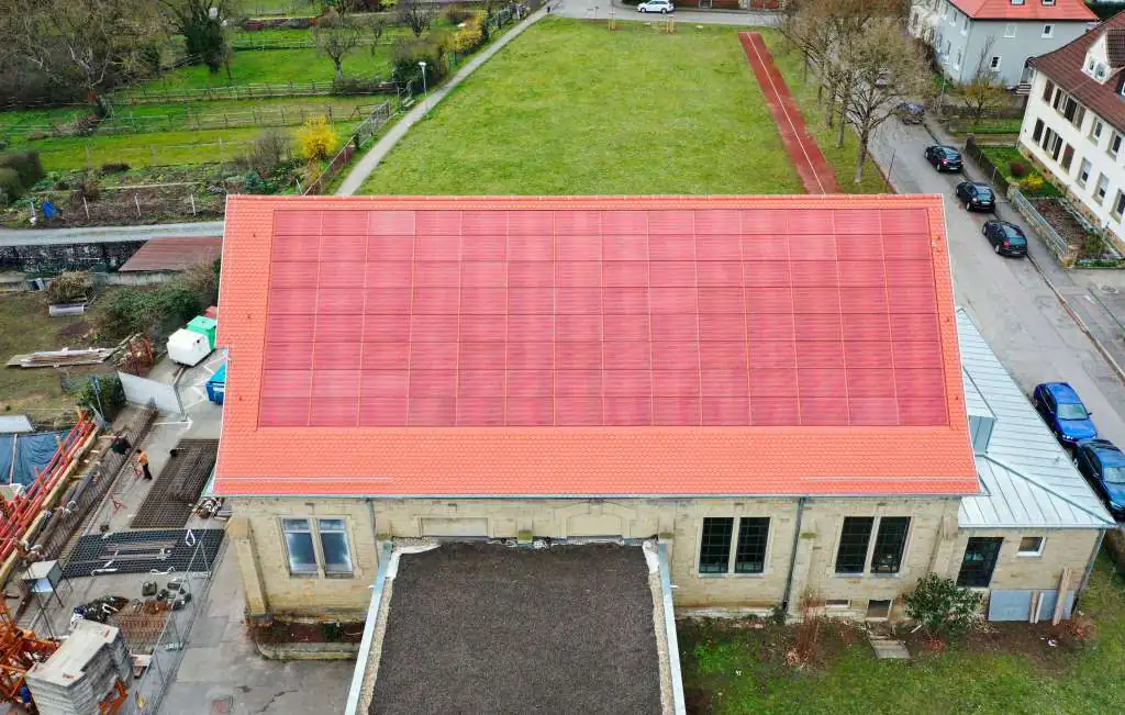 Im Rahmen des Forschungsprojekts »PVHide« wurde eine ziegelrote PV-Anlage direkt in das Dach eines historischen Gebäudes integriert. © Fraunhofer ISE / Foto: Sarah de Carvalho