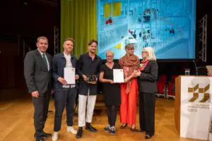 Auslober und Preisträger des Deutschen Architekturpreises 2023: Dirk Scheinemann, Abteilungsleiter im Bundesbauministerium, die Architekten Max Hacke und Gustav Düsing, Bettina Nöhren und Tatjana Schneider von der TU Braunschweig und Andrea Gebhard, Präsidentin der Bundesarchitektenkammer (v. l. n. r.); Quelle: Christoph Petras