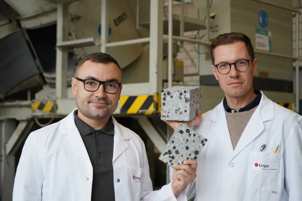 Beton ohne Emissionen: Empa-Forscher Mateusz Wyrzykowski (rechts) und Nikolajs Toropovs ersetzen herkömmliche Gesteinskörnungen durch Pellets aus Pflanzenkohle und loten damit das Potenzial von CO₂-neutralem oder gar CO₂-negativem Beton aus. Bild: Empa